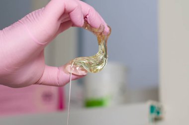 epilasyon ve güzellik kavramı - şeker yapıştırın veya saç Güzellik uzmanı spa salonda pembe eldiven El ile kaldırma için bal balmumu