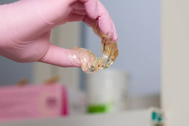 epilasyon ve güzellik kavramı - şeker yapıştırın veya saç Güzellik uzmanı spa salonda pembe eldiven El ile kaldırma için bal balmumu