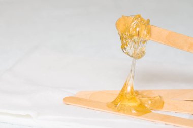tüy dökümü ve güzellik konsepti - şeker yapıştırıcı veya balmumu saç için bal ahşap spatula çubuklarıyla kaldırma