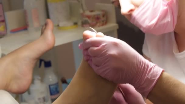 专业硬件修脚采用粉红色手套和电器机 患者在医疗修脚程序 访问足科医生 剥皮的脚 足疗沙龙的足部护理 足疗诊所 — 图库视频影像
