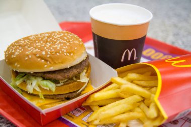 Russia, Saint-Petersburg, December 24, 2018: Hamburger menu in McDonald's restaurant Fries, coffee capuccino, Big Mac. Fastfood and junk food concept clipart