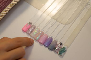 Manikür ve tırnak bakım kavramı. Güzellik Salonu bir kadında renkli test tırnak cilaları farklı renklerle tutar ve boyama için renk seçer.