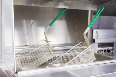 Fritöz patates ve nuggets için. Yeni temiz boş mutfak. Ekipman gıda paslanmaz çelikten yapılmıştır. Fritöz için sepetler. Kavram fast food restoran