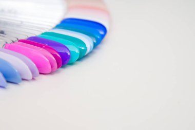 Tırnak bakımı ve manikür kavramı. İstemcinin çivi seçimi için çok renkli oje paleti. Kadın güzellik salonu. Boşaltmak için metin.