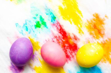Renkli Paskalya yumurta çerçeve kenarlığı çok renkli boyalı arka plan üzerinde. üstten görünüm, boşaltmak.
