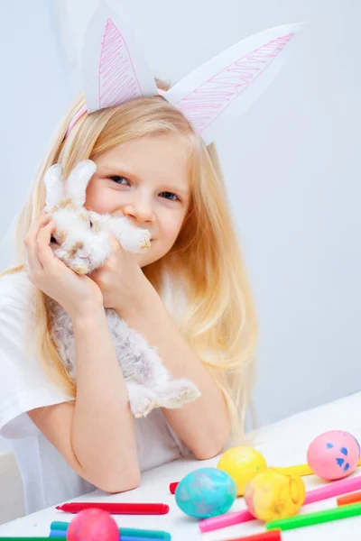 Блондинка Кроличьими Ушами Голове Кроликом Руках Красочные Яйца Маркеры Столе — стоковое фото