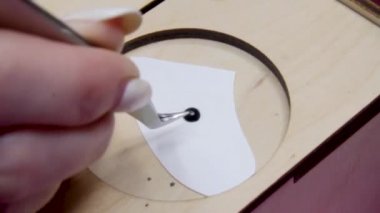 Kirpik uzatma prosedürü. Closeup Master kirpik uzatma yeni bir kirpik alır ve cımbız ile siyah tutkal daldırma uzun yanlış kirpik ile kadın göz.
