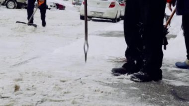 Servis şirketi evin avlusunda ve kar ve buzdan kaldırımlar temizler. Üniformalı iki adam çalışıyor, elinde kürek tutuyor..