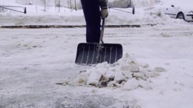 Servis şirketi evin avlusunda ve kar ve buzdan kaldırımlar temizler. Üniformalı iki adam çalışıyor, elinde kürek tutuyor..