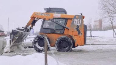 St-Petersburg, Rusya, 08 Feb 2019-hizmet şirketi ev ve kar ve buzdan kaldırımlar bahçesinde temizler. Bobcat veya Skid Loader kar-kaldırma küçük traktör kova ile yol temizler