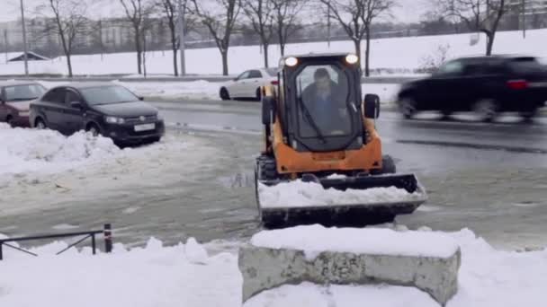 サンクトペテルブルク ロシア 2019 サービス会社は 家の庭と雪と氷から歩道を清掃します ボブキャットまたはスキッドローダースノー除去小型トラクターは バケツで道路をきれいにします — ストック動画