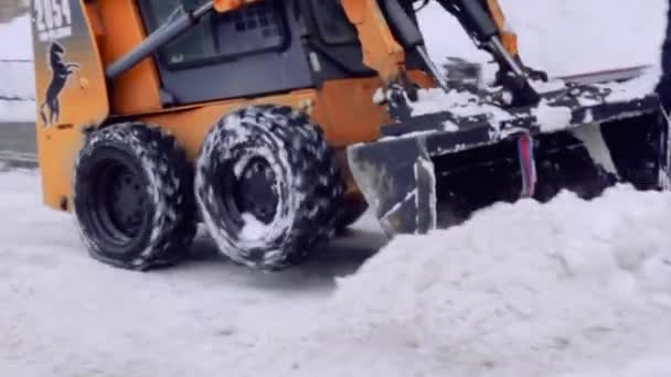 サンクトペテルブルク ロシア 2019 サービス会社は 家の庭と雪と氷から歩道を清掃します ボブキャットまたはスキッドローダースノー除去小型トラクターは バケツで道路をきれいにします — ストック動画