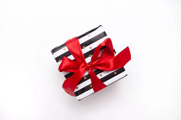 礼品或礼物盒在白色和黑色条纹与红色丝带弓查出在白色桌面视图。最低限度的平面组合销售, 生日, 母亲节或圣诞节。复制空间 — 图库照片