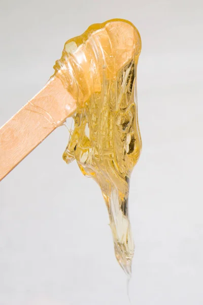Pasta de azúcar o miel de cera para la depilación con espátulas de cera de madera - depilación y concepto de belleza —  Fotos de Stock