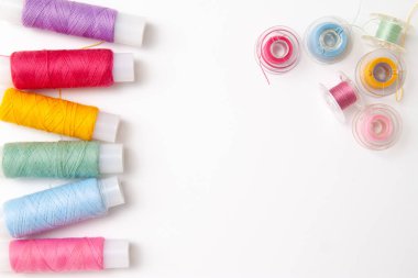 Beyaz arka plan üzerinde renkli iplik bobinleri. Dikiş malzemeleri ve aksesuarlar, dikiş, dikiş, nakış. boşaltmak. düz yatıyordu. Üstten Görünüm