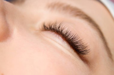 Kirpik uzatma yordamı. Kadın uzun yanlış Eyelashes gözle. Moda gözleri visagein güzellik salonu içinde makro çekim kapatın