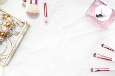 pembe profesyonel makyaj fırçaları parfüm boncuk ve küpe beyaz arka plan üzerinde kutusundaki metin için çerçeve. Güzellik ve moda kavramı. Üstten Görünüm düz yatıyordu. boşaltmak