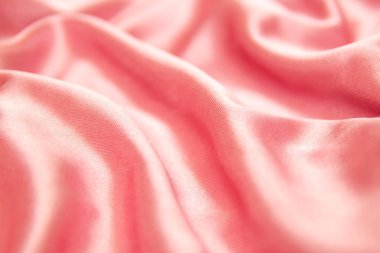 Tekstil ve doku kavramı - buruşuk ipek pembe dalgalı kumaş arka plan yakın.
