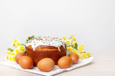 Paskalya pastası ve renkli yumurta arka planda sarı çiçek çiçekleri. Tatil yemekleri ve paskalya konsepti. Seçici odak. Copyspase