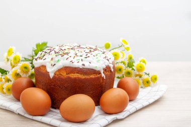 Paskalya pastası ve renkli yumurta arka planda sarı çiçek çiçekleri. Tatil yemekleri ve paskalya konsepti. Seçici odak. Copyspase