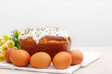 Paskalya pastası ve renkli yumurta arka planda sarı çiçek çiçekleri. Tatil yemekleri ve paskalya konsepti. Seçici odak. Copyspase