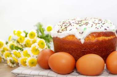 Paskalya pastası ve renkli yumurta arka planda sarı çiçek çiçekleri. Tatil yemekleri ve paskalya konsepti. Seçici odak. Copyspase