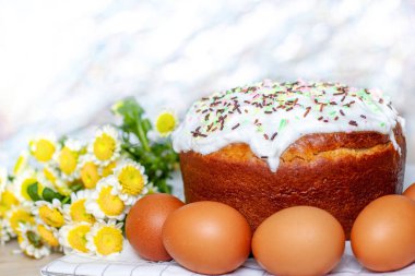 Paskalya pastası ve renkli yumurta arka planda sarı çiçek çiçekleri. Tatil yemekleri ve paskalya konsepti. Seçici odak. Copyspase