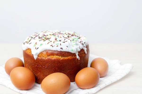 Easter cake and colored eggs on bright background. Holiday food and easter concept. Selective focus. Copyspase