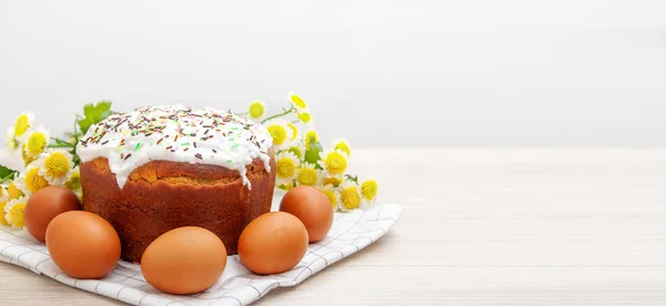 wide banner with Easter cake and colored eggs yellow flower blossoms on background. Holiday food and easter concept. Copyspase for text.