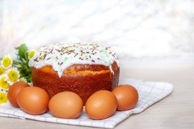 Paskalya pastası ve renkli yumurta arka planda sarı çiçek çiçekleri. Tatil yemekleri ve paskalya konsepti. Seçici odak. Copyspase
