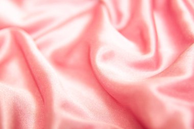 Tekstil ve doku kavramı - buruşuk ipek pembe dalgalı kumaş arka plan yakın.