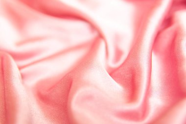 Tekstil ve doku kavramı - buruşuk ipek pembe dalgalı kumaş arka plan yakın.