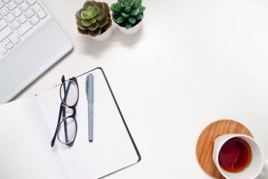Laptop, defter, sketchbook, etli, beyaz arka plan üzerinde çay ile çalışma alanı. Düz yatıyordu, en iyi görünümü office tablo Resepsiyon. Bağımsız çalışma yer. boşaltmak