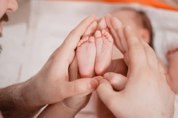 Embarazo, maternidad, preparación y expectativa maternidad, dando a luz concepto. Los pies recién nacidos en manos de los padres — Foto de Stock