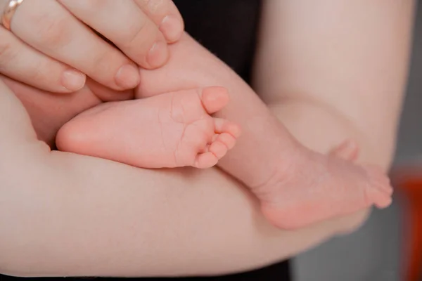 Embarazo, maternidad, preparación y expectativa maternidad, dando a luz concepto. Los pies recién nacidos en manos de los padres — Foto de Stock