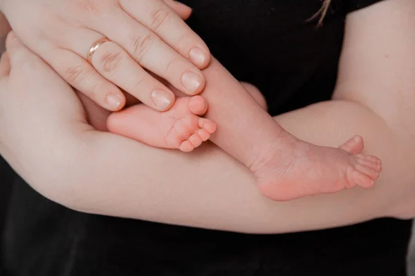 Pregnancy, maternity, preparation and expectation motherhood, giving birth concept. Newborn baby feet in hands of parents — Stock Photo, Image