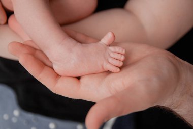 Gebelik, annelik, hazırlık ve beklenti annelik, doğum kavramı veren. Ebeveynlerin elinde yenidoğan bebek ayakları