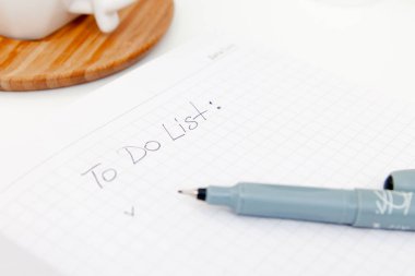 açılan not defterine, eskiz defterine, beyaz arka planda sulu listeye yazılan metin. Düz yatıyordu, üst görünüm ofis masa masası. Serbest çalışan bir çalışma yeri. copyspace