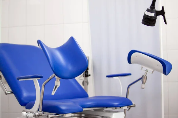 Gynäkologisches Kabinett im Krankenhaus mit blauem Stuhl und anderen medizinischen Geräten. Frauengesundheit, Neugeborenes und Schwangerschaftskonzept — Stockfoto