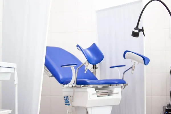 Gynäkologisches Kabinett im Krankenhaus mit blauem Stuhl und anderen medizinischen Geräten. Frauengesundheit, Neugeborenes und Schwangerschaftskonzept — Stockfoto