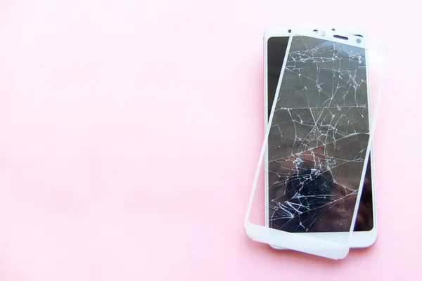 Smartphone móvil con pantalla de cristal rota aislada sobre fondo rosa. Copyspace fo texto. Servicio, reparación, tecnología y concepto de minimalismo . — Foto de Stock