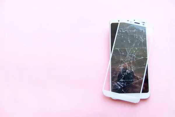 Smartphone móvil con pantalla de cristal rota aislada sobre fondo rosa. Copyspace fo texto. Servicio, reparación, tecnología y concepto de minimalismo . — Foto de Stock