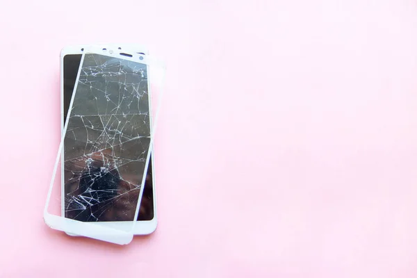 Smartphone móvil con pantalla de cristal rota aislada sobre fondo rosa. Copyspace fo texto. Servicio, reparación, tecnología y concepto de minimalismo . — Foto de Stock