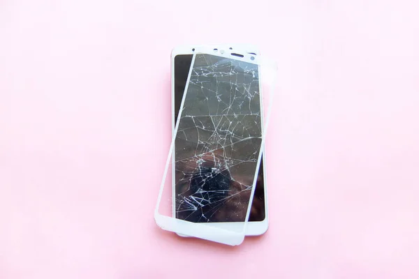 Smartphone móvil con pantalla táctil de cristal roto aislado sobre fondo rosa. Servicio, reparación, tecnología y concepto de minimalismo . — Foto de Stock