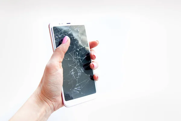 Smartphone móvil con pantalla de cristal roto en mano de mujer sobre fondo blanco. Copyspace fo texto. Concepto de servicio, reparación y tecnología — Foto de Stock