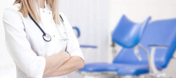 Gynecological banner with copyspace for text. Gynecologist doctor in white uniform in clinic hospital. cabinet with blue chair on background. Woman health and pregnancy concept.