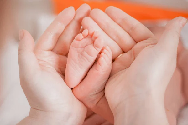 Pregnancy, maternity, preparation and expectation motherhood, giving birth concept. Newborn baby feet in hands of mommy — Stock Photo, Image