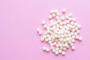 pembe arka planda homeopatik globüller. Alternatif Homeopati ilaç otlar, şifalı bakım ve hap kavramı. Düzlay. Üst te. metin için copyspace