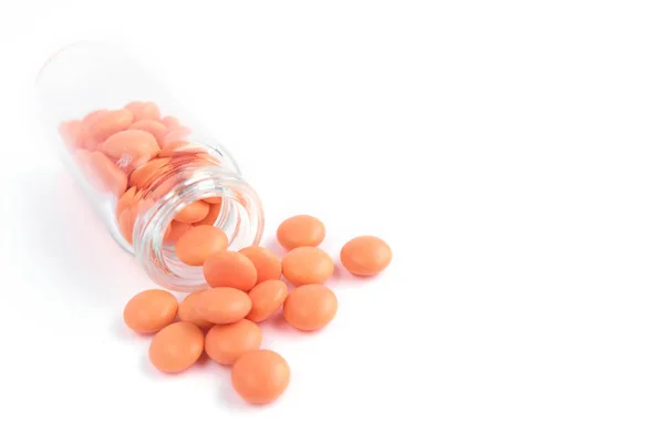 Oranžové tablety ze skleněné láhve na bílém podkladu. copyspace pro text. Epidemie, léky proti bolesti, zdravotní péče, prášky na léčbu a zneužívání drog — Stock fotografie