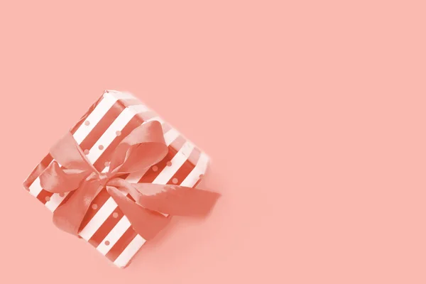 礼品或礼物盒条纹与丝带蝴蝶结色调与2019年的主要时尚活珊瑚颜色。销售、生日或圣诞节的最小平面布局组成。复制空间. — 图库照片